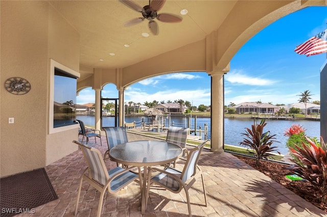 view of patio / terrace featuring a water view, a dock, and ceiling fan