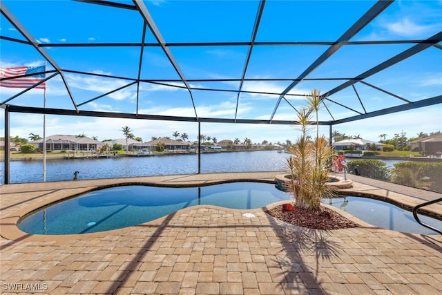 view of pool with a patio, a water view, and glass enclosure