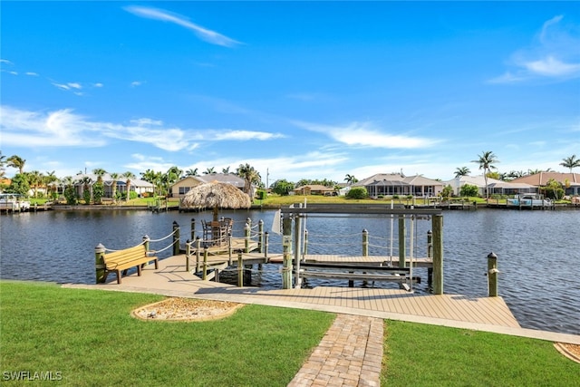 dock area featuring a water view and a lawn