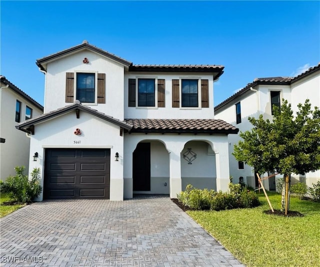 mediterranean / spanish-style home with a front yard and a garage