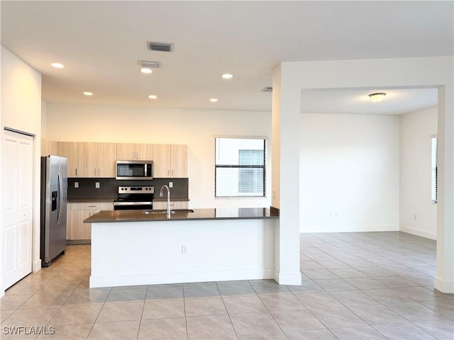 kitchen featuring kitchen peninsula, appliances with stainless steel finishes, light brown cabinetry, sink, and light tile patterned floors