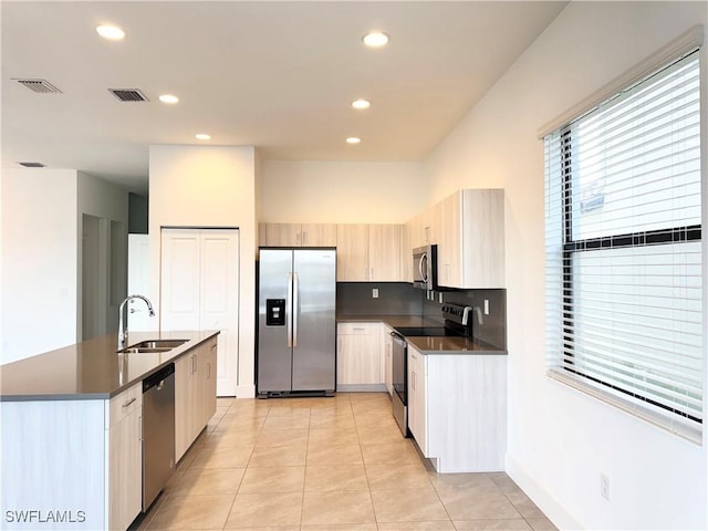 kitchen with appliances with stainless steel finishes, light tile patterned floors, and sink