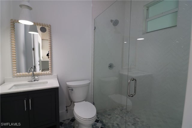 bathroom featuring toilet, a shower stall, and vanity