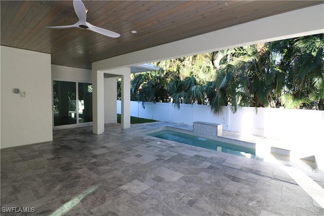 view of pool with a hot tub, ceiling fan, fence, and a patio