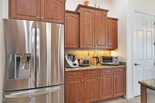 kitchen featuring appliances with stainless steel finishes, backsplash, and light stone counters