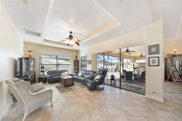 living room with a raised ceiling and light tile patterned floors