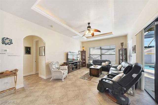 living room featuring ceiling fan, light tile patterned floors, and a tray ceiling