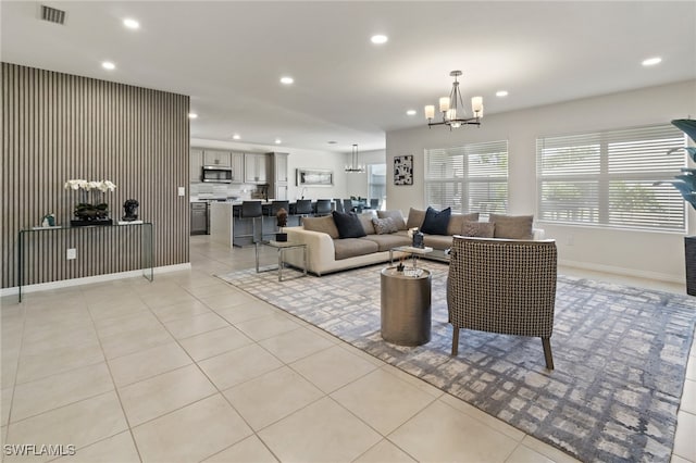 tiled living room with a notable chandelier