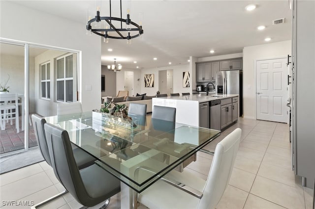 tiled dining space featuring an inviting chandelier and sink