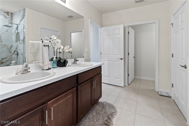 bathroom with tile patterned floors, a shower with door, and vanity