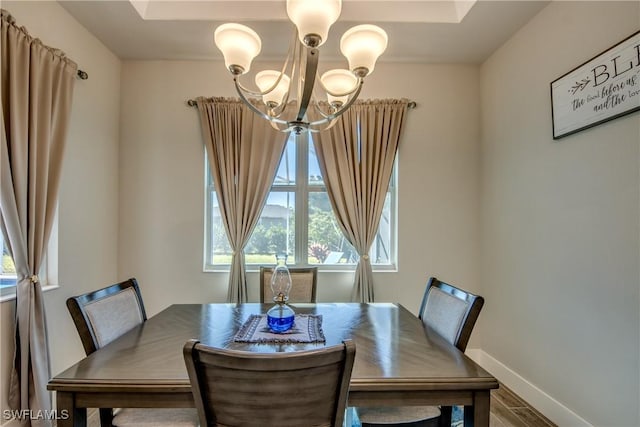 dining area featuring hardwood / wood-style floors and an inviting chandelier