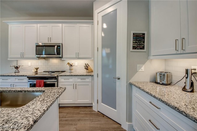 kitchen featuring white cabinets, appliances with stainless steel finishes, and light wood-type flooring