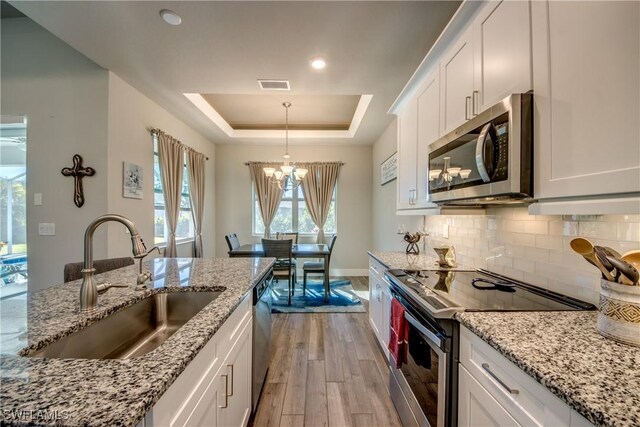 kitchen featuring white cabinets, sink, appliances with stainless steel finishes, and light hardwood / wood-style flooring