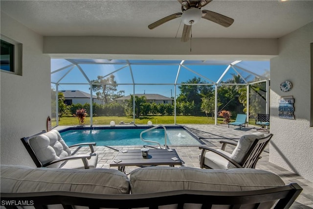 view of swimming pool with an outdoor living space, a yard, glass enclosure, and a patio area