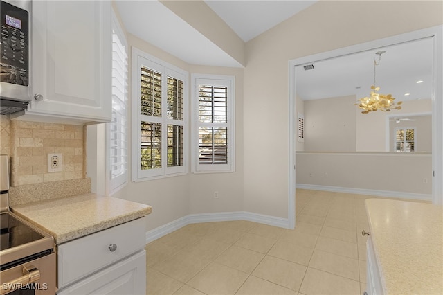 kitchen featuring pendant lighting, decorative backsplash, a notable chandelier, white cabinetry, and stainless steel appliances