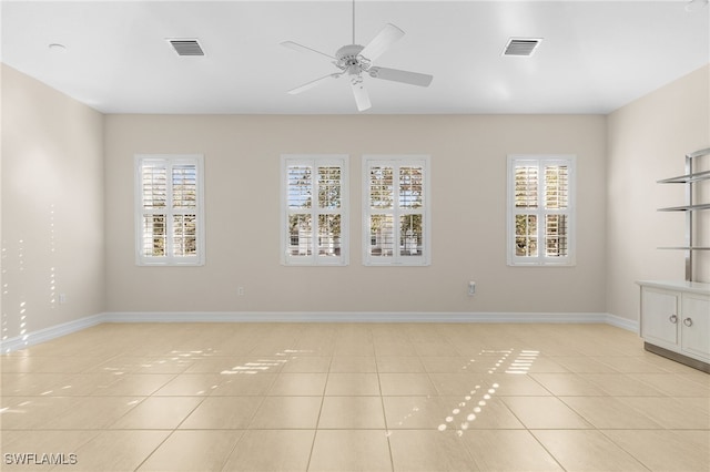 tiled spare room with ceiling fan