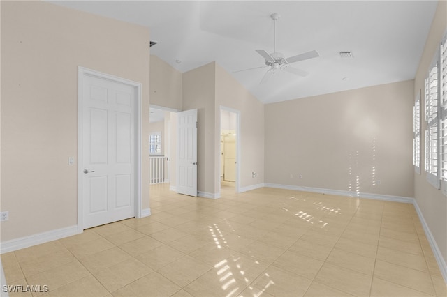 tiled spare room with ceiling fan and vaulted ceiling