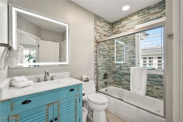 full bathroom with enclosed tub / shower combo, vanity, a healthy amount of sunlight, and toilet