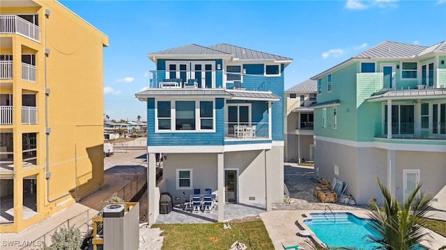 rear view of house featuring a balcony and a patio