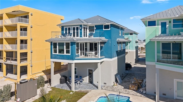 back of property featuring a patio area and a balcony