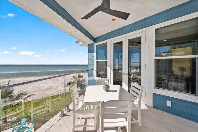 balcony featuring a beach view, french doors, a water view, and ceiling fan