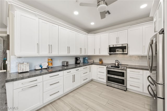 kitchen with white cabinets, appliances with stainless steel finishes, tasteful backsplash, and ceiling fan