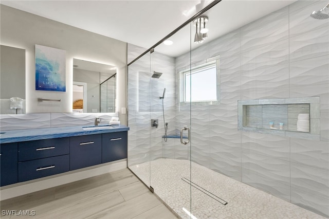 bathroom featuring vanity and a shower with shower door