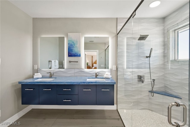 bathroom with hardwood / wood-style floors, vanity, and walk in shower