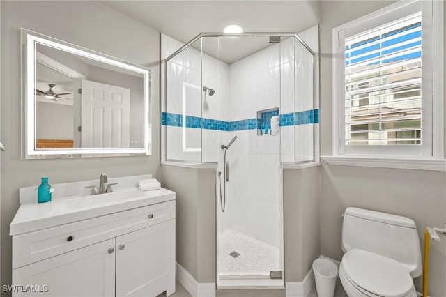 bathroom with ceiling fan, vanity, an enclosed shower, and toilet