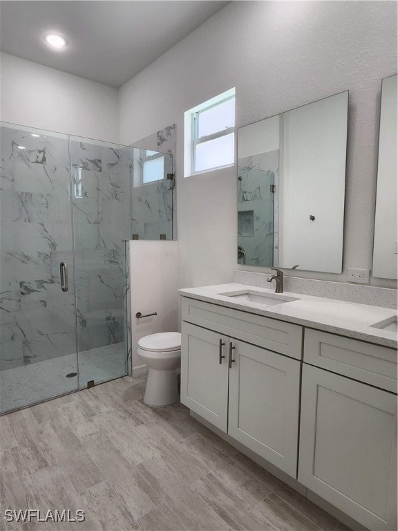 bathroom featuring vanity, toilet, wood-type flooring, and walk in shower