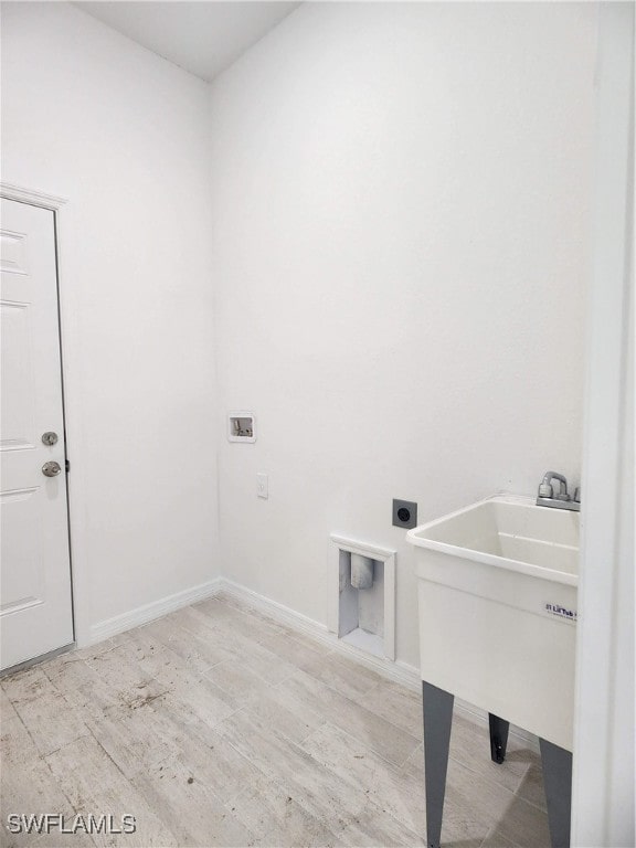 clothes washing area with hookup for an electric dryer, washer hookup, and light hardwood / wood-style flooring