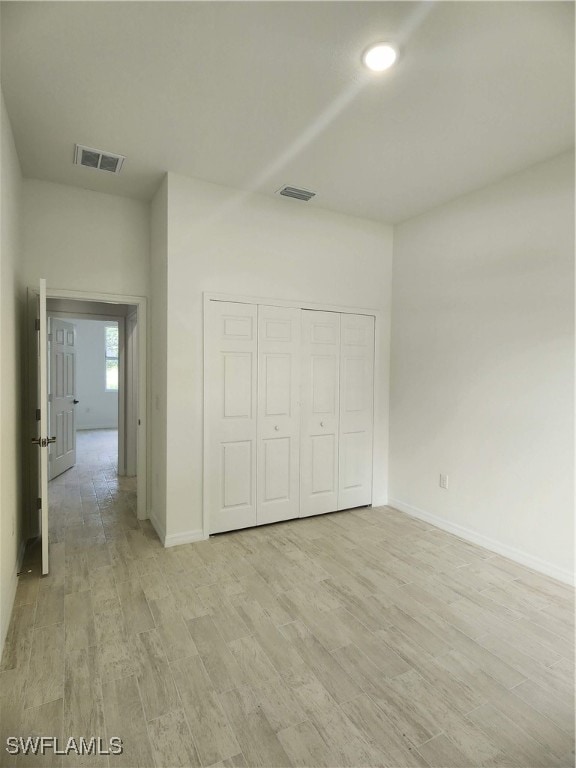 unfurnished bedroom with light hardwood / wood-style floors and a closet