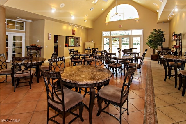 dining area with ceiling fan, light tile patterned floors, high vaulted ceiling, and french doors