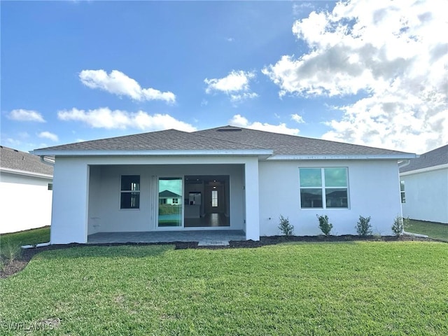 rear view of house with a patio and a lawn