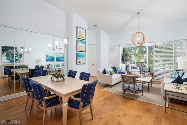 dining area with light hardwood / wood-style floors and an inviting chandelier