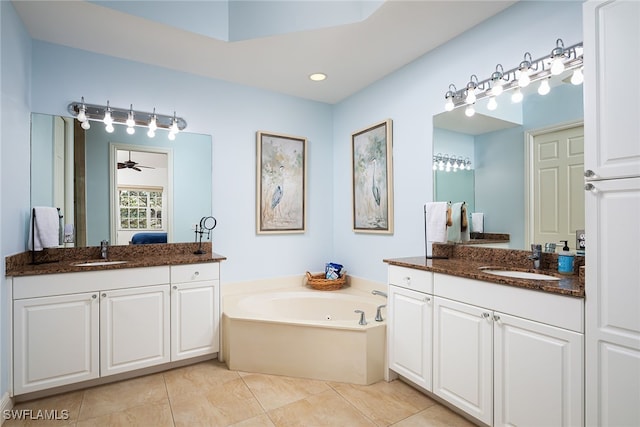 bathroom with tile patterned floors, vanity, ceiling fan, and a tub to relax in