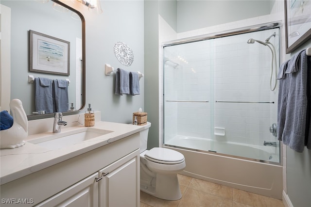 full bathroom with tile patterned floors, toilet, vanity, and combined bath / shower with glass door