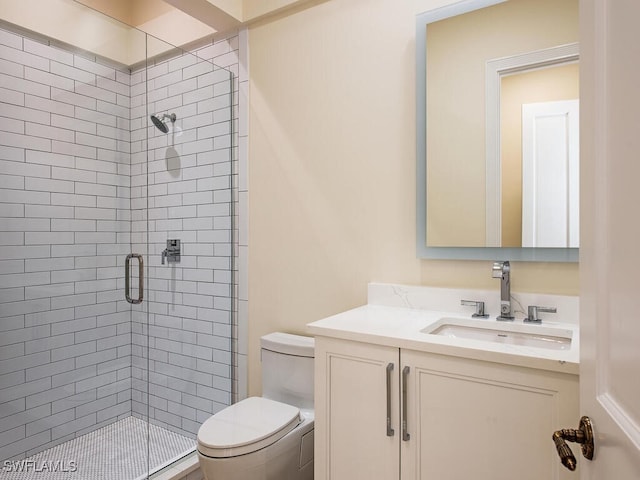 bathroom featuring a shower with door, vanity, and toilet