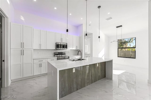 kitchen with a center island with sink, sink, white cabinetry, and stainless steel appliances