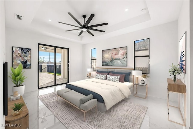 bedroom with ceiling fan, a raised ceiling, and access to outside