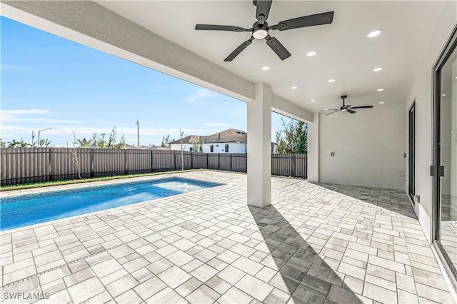 view of swimming pool with ceiling fan and a patio