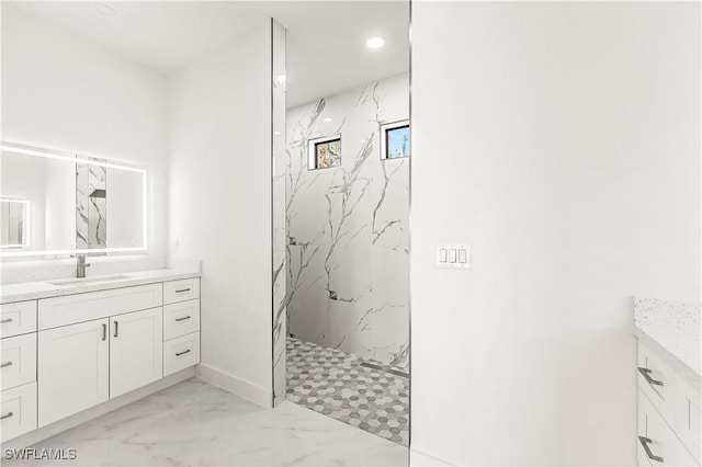 bathroom featuring a tile shower and vanity