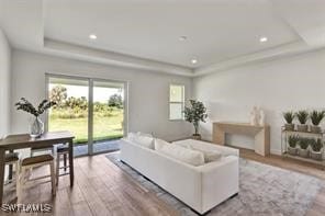 living room featuring a tray ceiling and hardwood / wood-style flooring