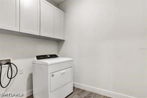 washroom with cabinets, washer / dryer, and wood-type flooring