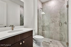 bathroom with an enclosed shower, vanity, and toilet