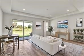 living room with hardwood / wood-style floors and a tray ceiling