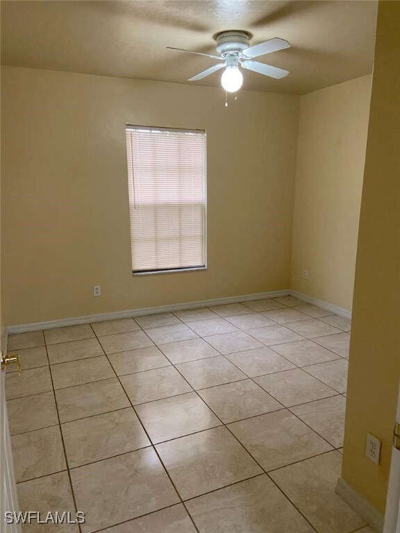 unfurnished room featuring ceiling fan and light tile patterned floors