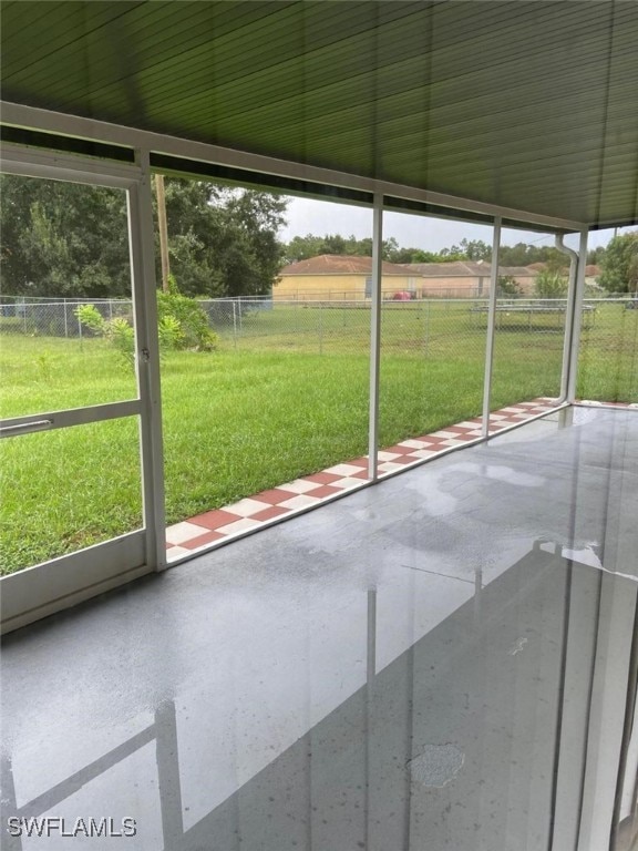 unfurnished sunroom featuring a wealth of natural light and a rural view