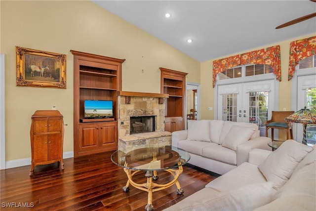 living room featuring dark wood-type flooring, high vaulted ceiling, french doors, a stone fireplace, and ceiling fan