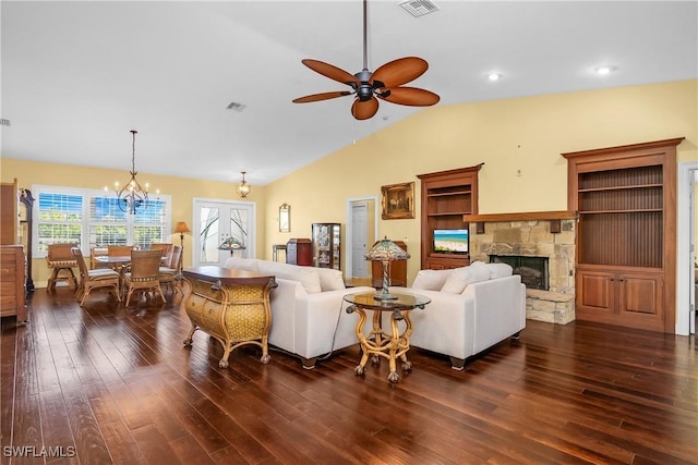 living room with dark hardwood / wood-style floors, a fireplace, ceiling fan with notable chandelier, and vaulted ceiling